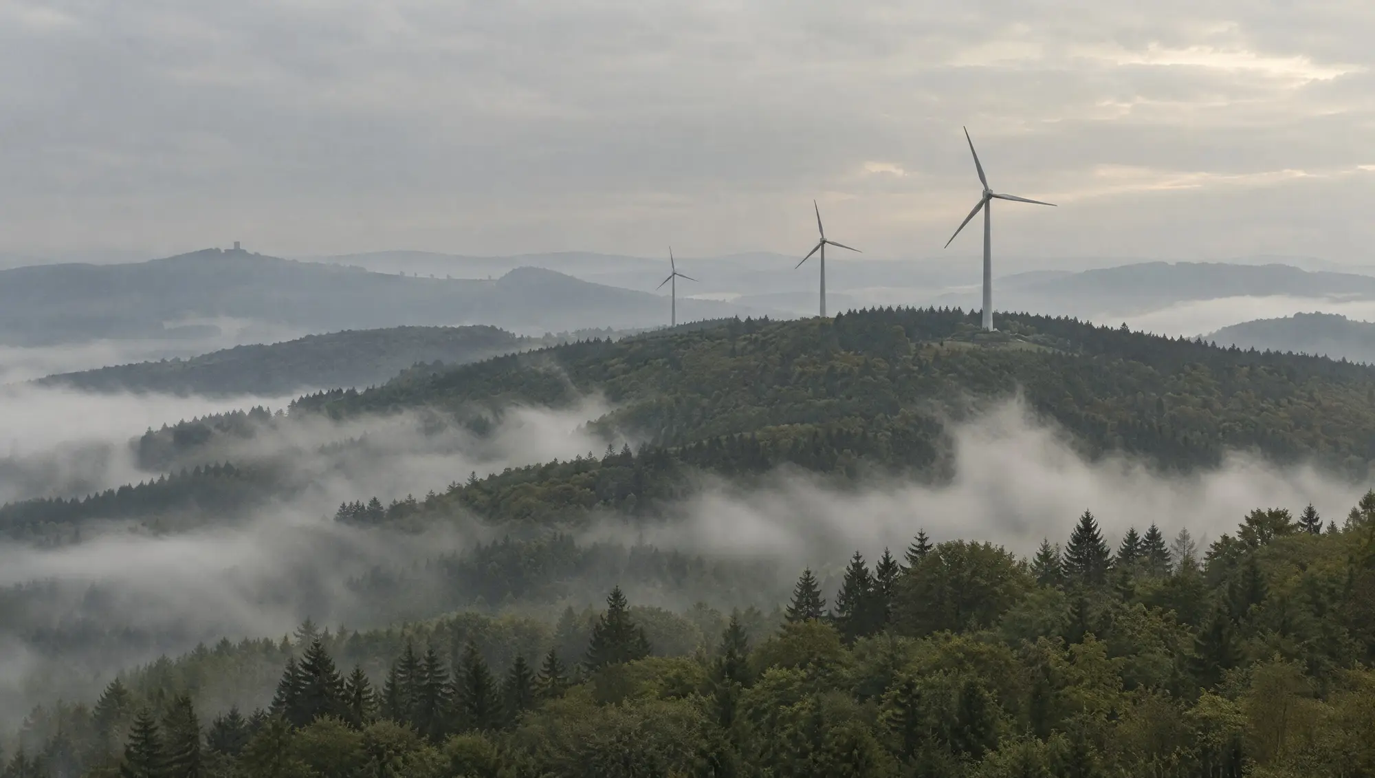 Wind turbines on a ridge in morning fog